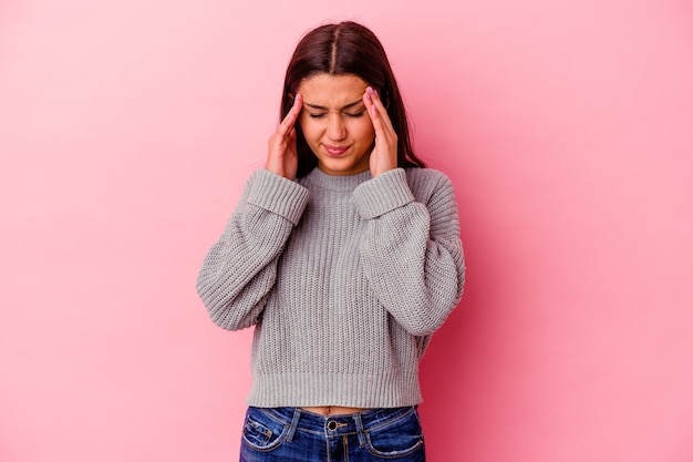 Young Indian woman isolated on pink wall touching temples and having headache.