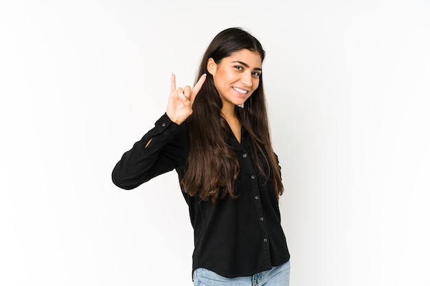 Young indian woman isolated on purple space showing a horns gesture as a revolution concept.