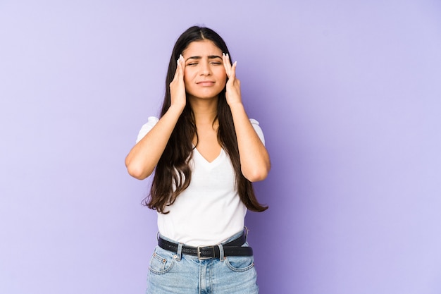 Young indian woman isolated on purple wall whining and crying disconsolately.