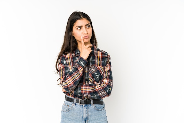 Young indian woman looking sideways with doubtful and skeptical expression.