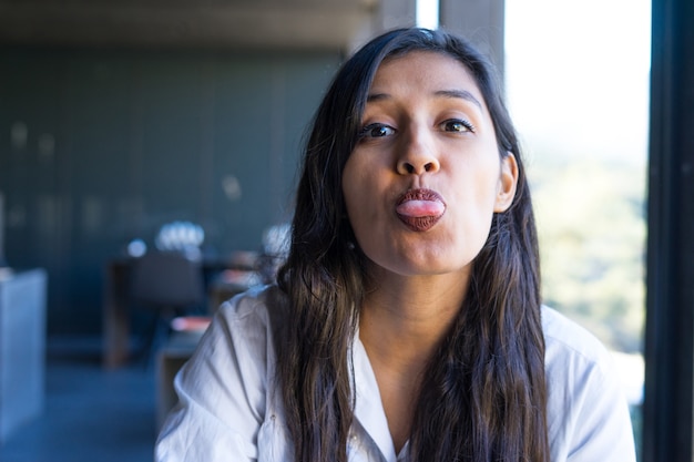 young indian woman showing tongue