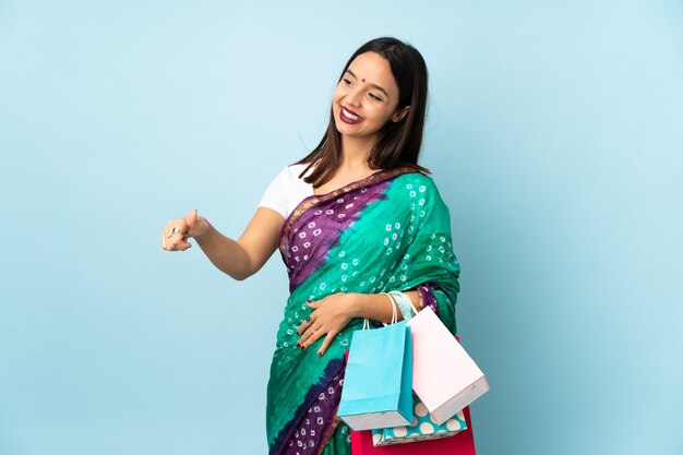 Young Indian woman with shopping bags giving a thumbs up gesture