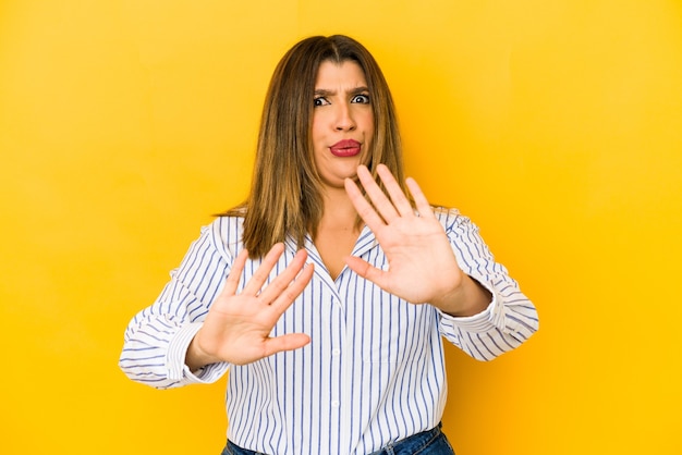 Photo young indian woman on yellow rejecting someone showing a gesture of disgust.