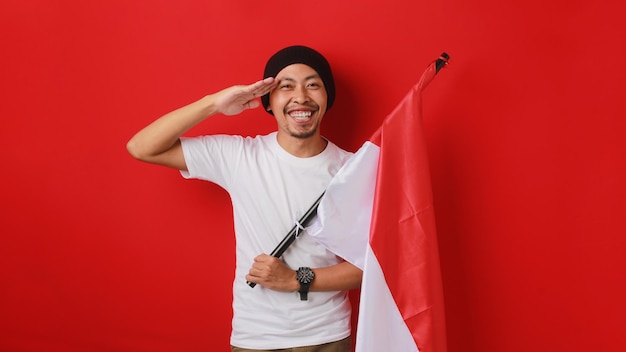 Photo young indonesian man saluting on indonesias independence day