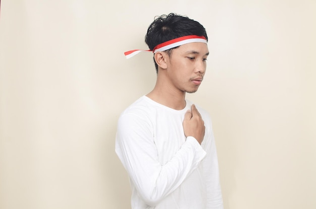 Young Indonesian man with hands on chest celebrating independence day