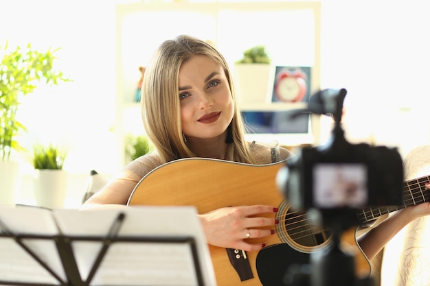 Young influencer blogger plays guitar filming an educational vlog