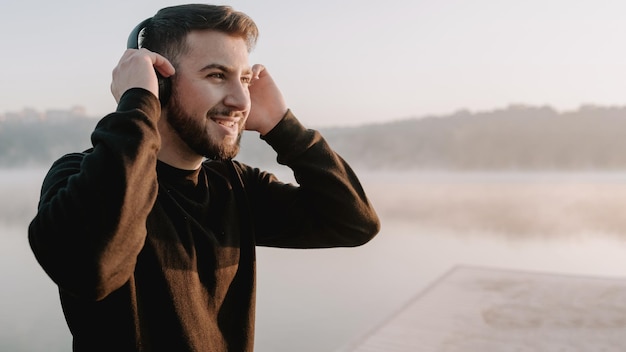 Young inspired man listening to music in the morning