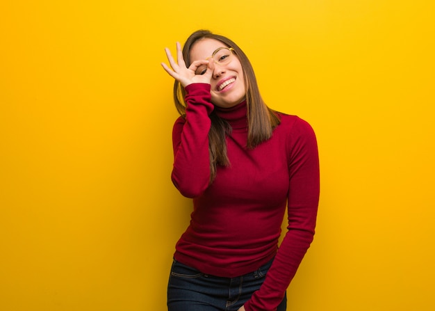 Young intellectual woman confident doing ok gesture on eye