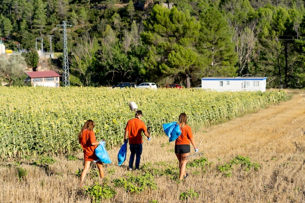 Photo young janitors working in the woods collecting garbage.