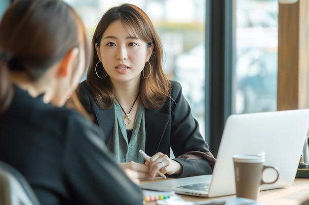 A young Japanese businesswoman is conducting an interview with another at the table