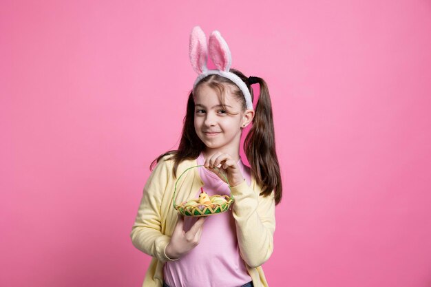 Young joyful child posing with easter eggs and toys on camera