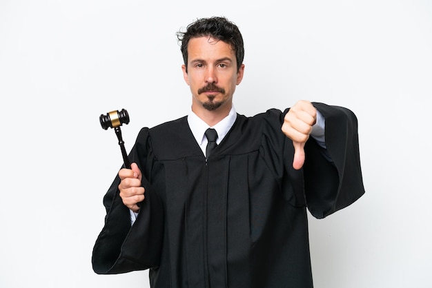 Young judge caucasian man isolated on white background showing thumb down with negative expression