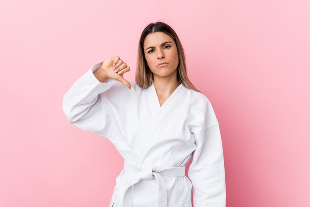 Young karate woman showing a dislike gesture, thumbs down. Disagreement concept.