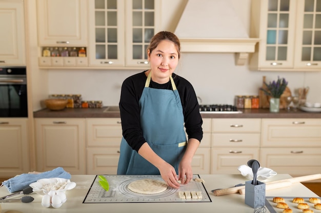 Young kazakh woman is cooking baking in the interior of a modern home kitchen