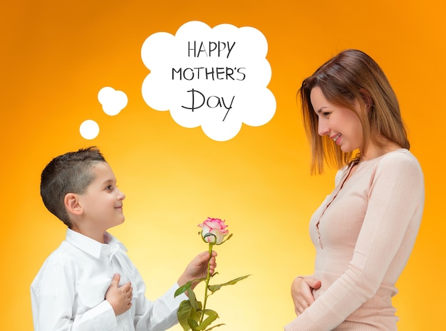 Young kid giving red rose to his mom. Happy mothers day concept