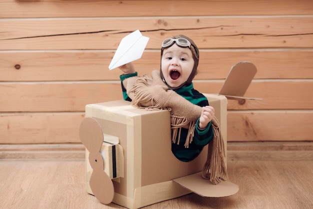 Young kid pilot flying a cardboard box