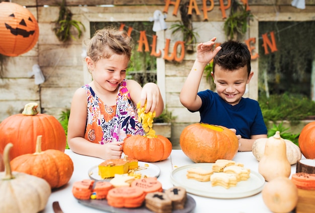 Young kids carving Halloween jack-o&#39;-lanterns