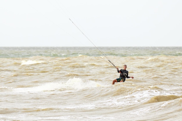 A young kiteboarder rides the waves into the sea