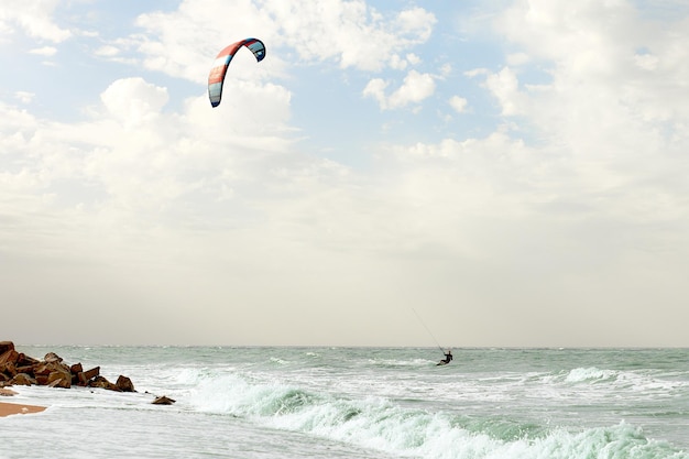 A young kiteboarder rides the waves into the sea