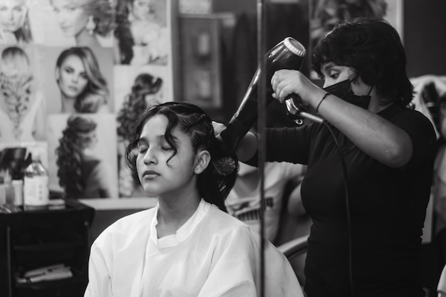 Young lady applying makeup in a spa or hair salon, black and white color photo.