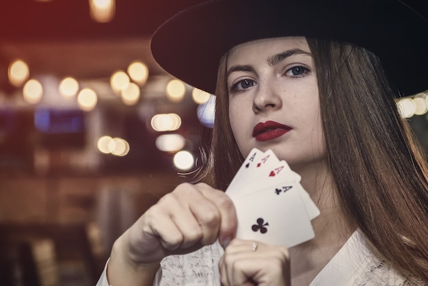 Young lady in casino with four aces