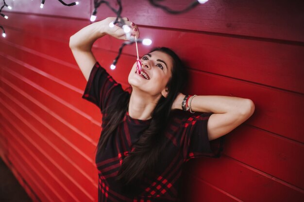 young lady in dress standing near decorated house for Christmas