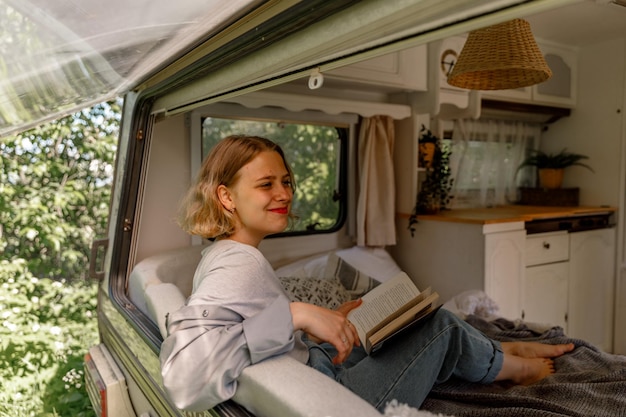 A young lady enjoys summer vacation in a campvan