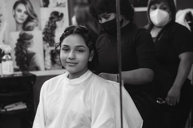 Young lady getting makeup and hair done in a professional spa or hair salon. black and white photo