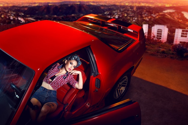 Young lady posing in a red car