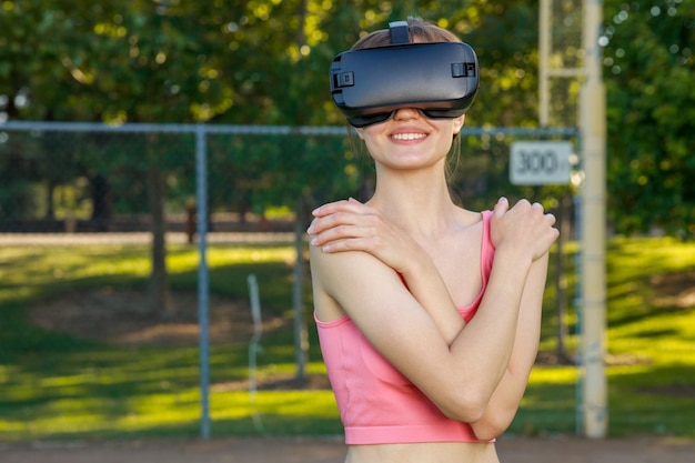 Young lady wearing VR set and holding her hand to her shoulder