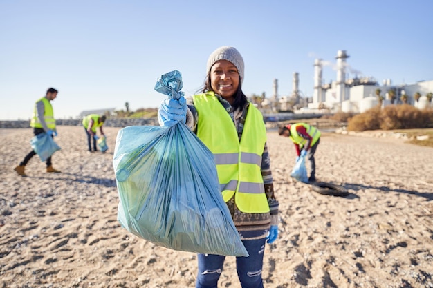 Photo young latin activist looking at camera holding a garbage bag trash