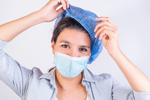 Young latin american doctor contentedly removing her cap doctors investigating an infection