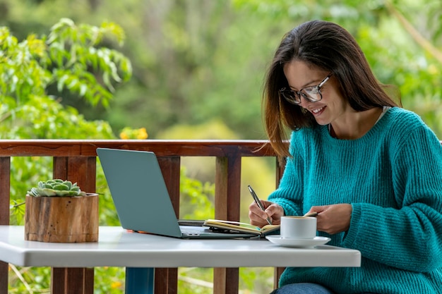 Young Latin American woman working on her laptop at a outdoor cafe Panama Central America