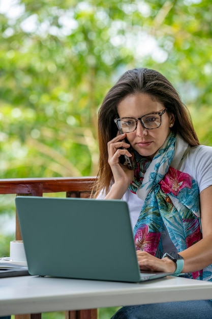 Young Latin American woman working on her laptop at a outdoor cafe Panama Central America