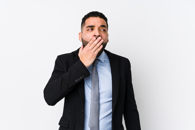 Young latin business woman against a white wall yawning showing a tired gesture covering mouth with hand.