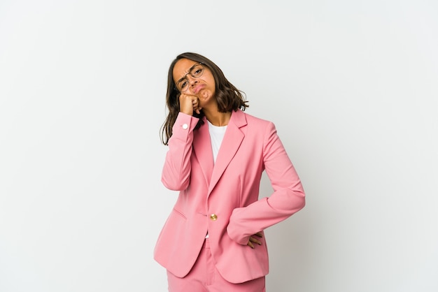 Young latin business woman isolated on white wall smiling and pointing aside, showing something at blank space.