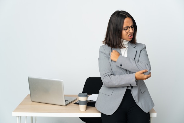 Young latin business woman working in a office isolated on white background with pain in elbow