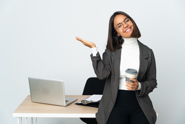 Young latin business woman working in a office isolated on white extending hands to the side for inviting to come