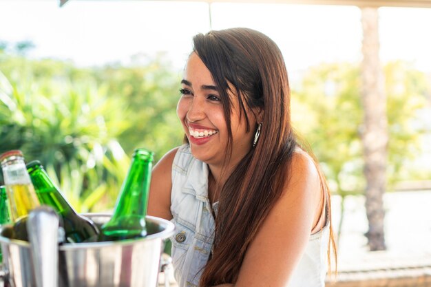 Young latin enjoying with her friends over drinks Smiling Hispanic girl having a few beers