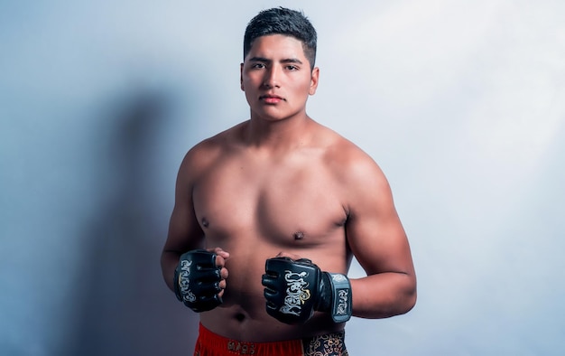 Young latin fit fighter with showing fists in boxing gloves fight portrait