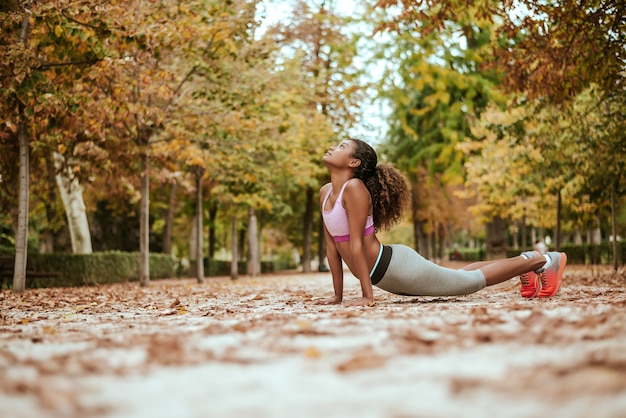 Young latin girl doing fitness training in park.