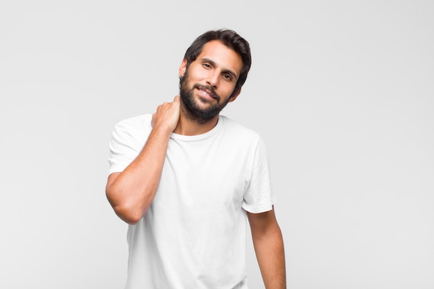 Young latin handsome man posing relaxed with hand on neck