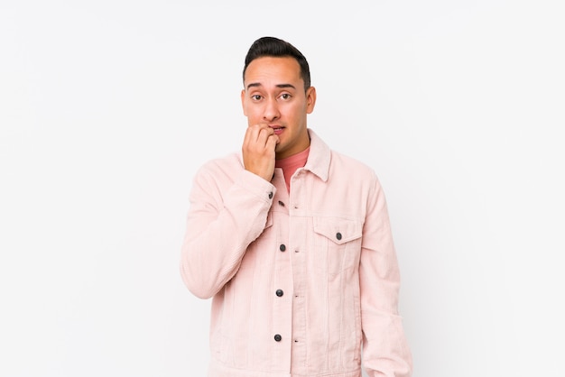 Young latin man posing isolated biting fingernails, nervous and very anxious.