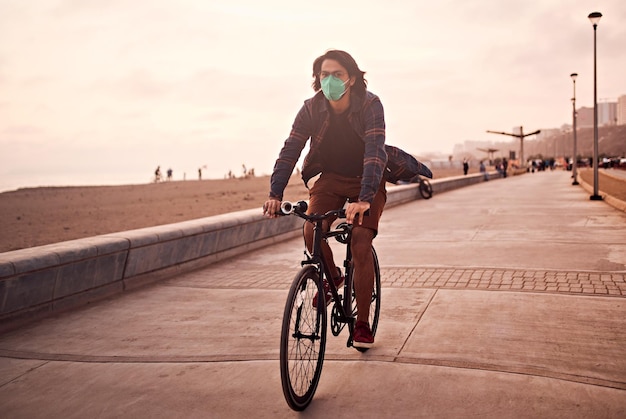 Young Latin man rides a bicycle during a beautiful sunset