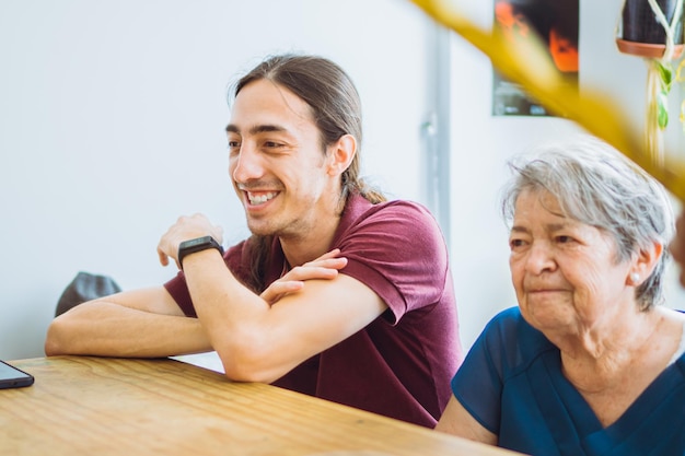 Young latin man with his grandmother sharing a family moment