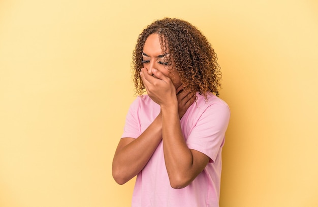 Young latin transsexual woman isolated on yellow background suffers pain in throat due a virus or infection.