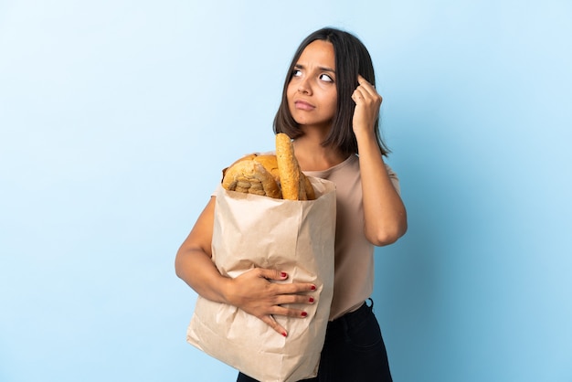 Young latin woman buying some breads