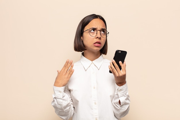 Young latin woman feeling stressed, anxious, tired and frustrated, pulling shirt neck, looking frustrated with problem