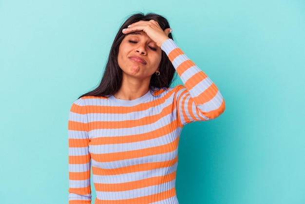 Young latin woman isolated on blue background touching temples and having headache.