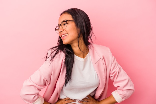 Young latin woman isolated on pink background  confident keeping hands on hips.